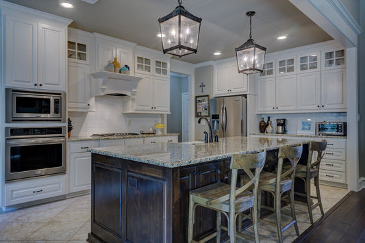 Modern kitchen with white cabinets, granite countertops, and stainless steel appliances.